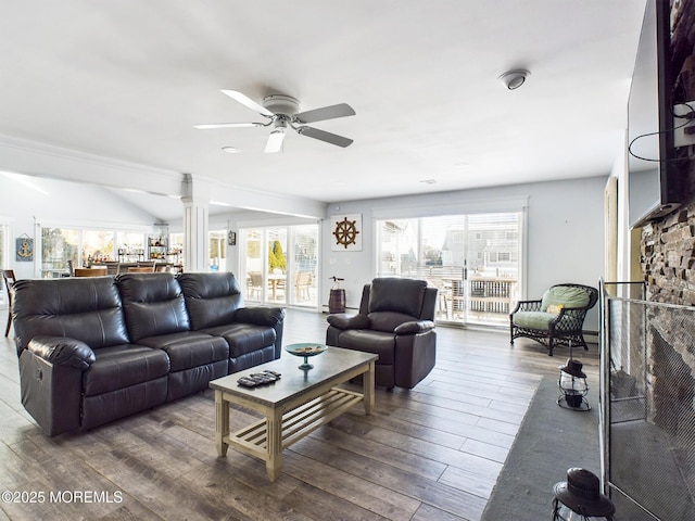 living room featuring wood-type flooring, decorative columns, and ceiling fan