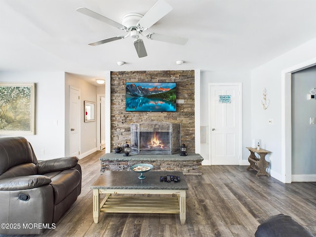 living room featuring wood-type flooring, ceiling fan, and a fireplace