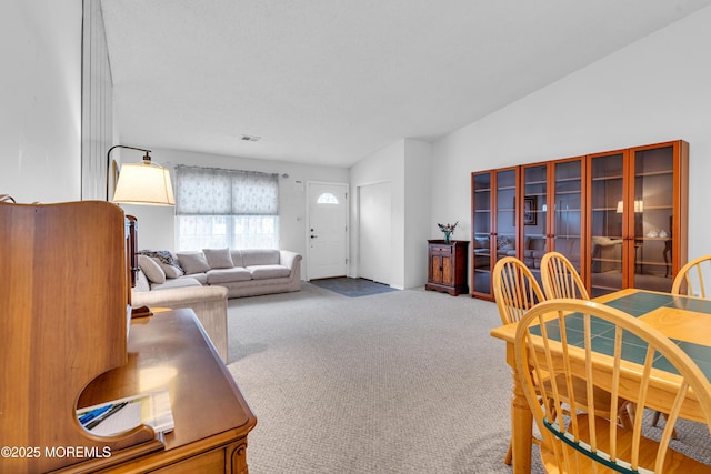 carpeted living room with vaulted ceiling