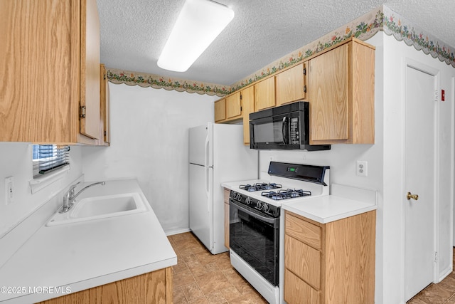 kitchen featuring a textured ceiling, sink, range with gas stovetop, white refrigerator, and light brown cabinets