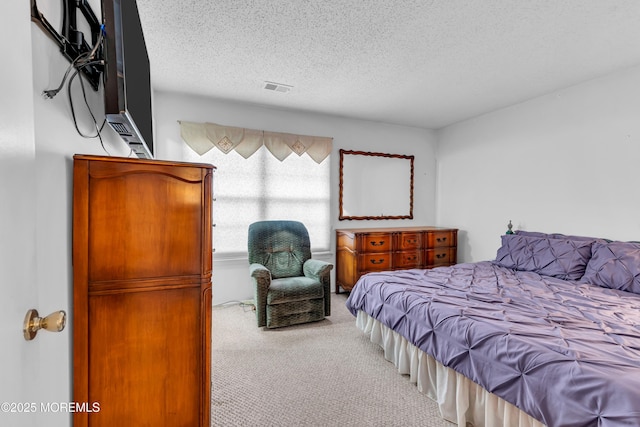 bedroom featuring a textured ceiling and light carpet