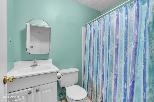 bathroom featuring toilet, a textured ceiling, a shower with shower curtain, and vanity