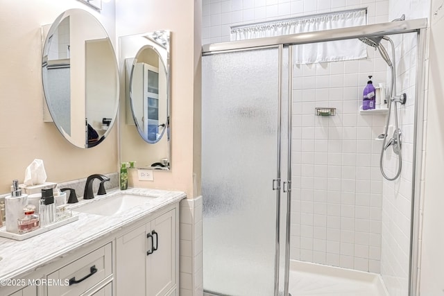 bathroom with a shower with door and vanity