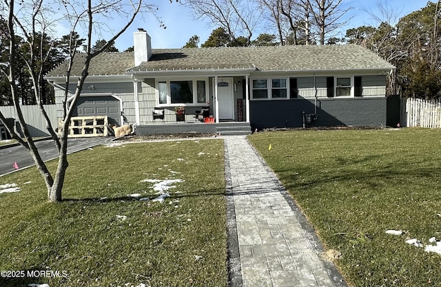 ranch-style house featuring a garage and a front lawn