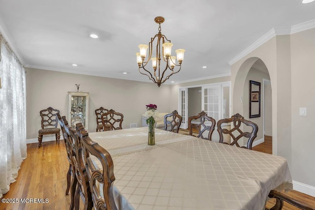 dining room featuring light hardwood / wood-style flooring, ornamental molding, and a chandelier