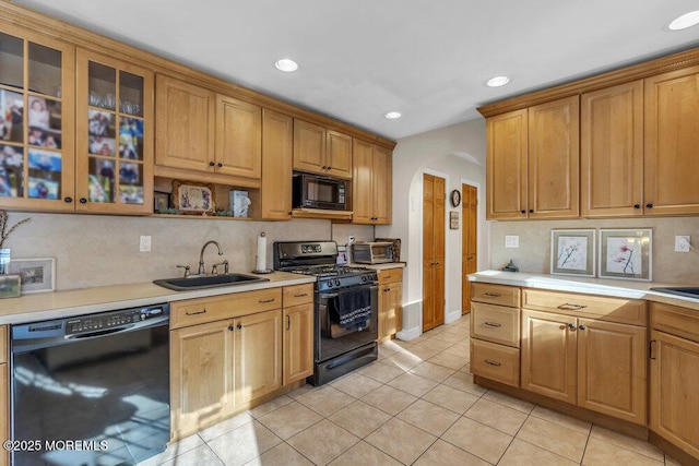 kitchen with tasteful backsplash, light tile patterned floors, sink, and black appliances