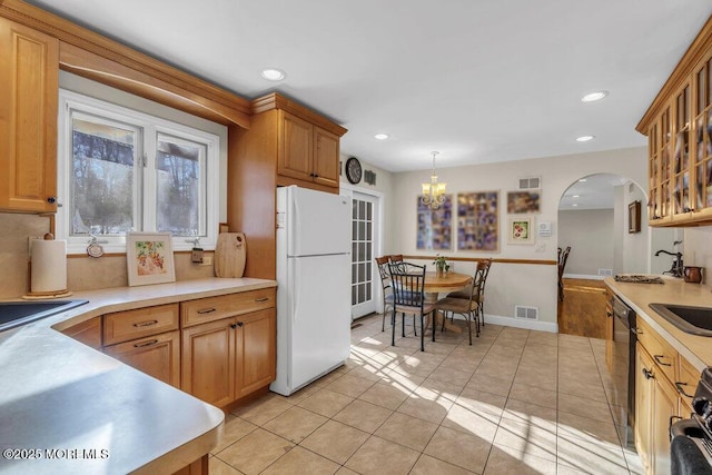 kitchen featuring dishwasher, range, hanging light fixtures, white refrigerator, and light tile patterned flooring