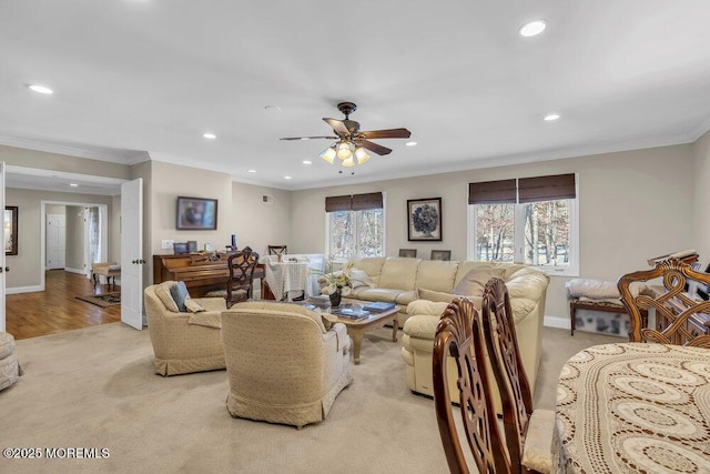 carpeted living room featuring ceiling fan and ornamental molding