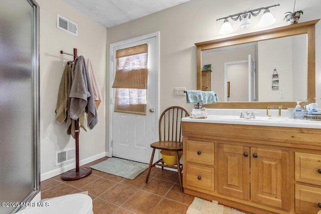 bathroom with tile patterned flooring, vanity, and a shower with door