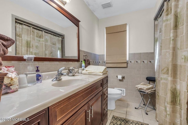 bathroom featuring tile patterned floors, toilet, tile walls, and vanity