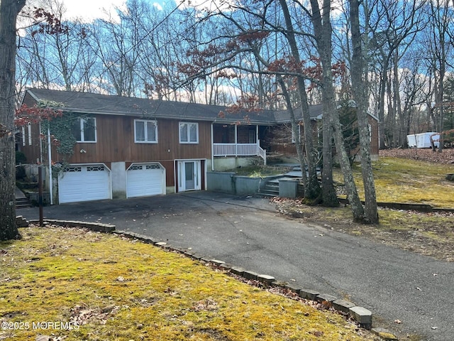 view of front facade with a garage, a porch, and a front yard