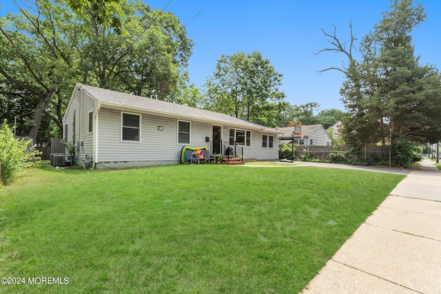 ranch-style home featuring central AC unit and a front lawn