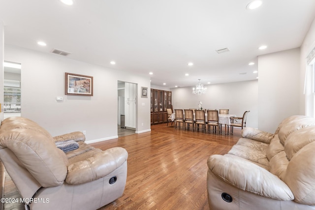 living room with a chandelier and light hardwood / wood-style floors