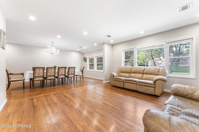 living room with a chandelier and light hardwood / wood-style flooring