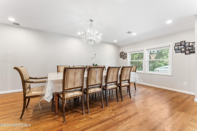 dining room with light hardwood / wood-style floors and a notable chandelier