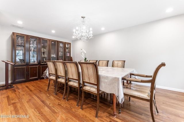 dining space with a chandelier and light hardwood / wood-style flooring