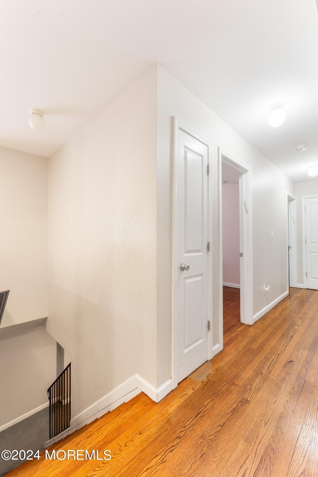 corridor with hardwood / wood-style floors