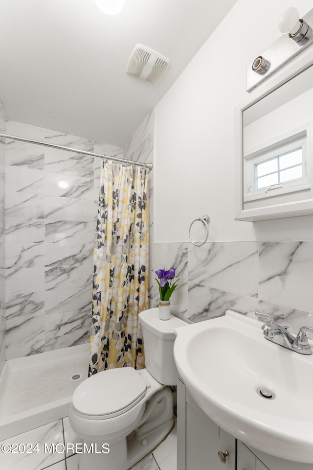 bathroom featuring walk in shower, vanity, toilet, and tile walls