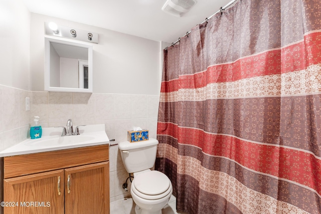 bathroom with vanity, tile walls, and toilet