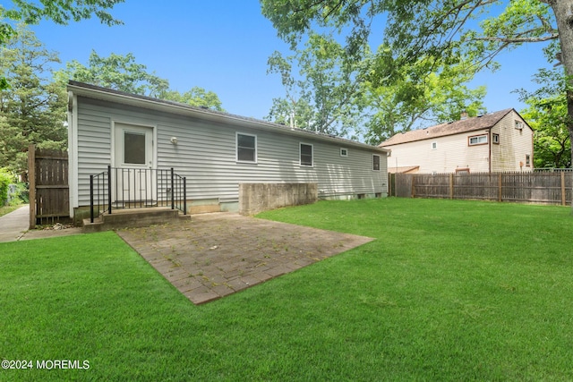 rear view of property featuring a patio area and a yard