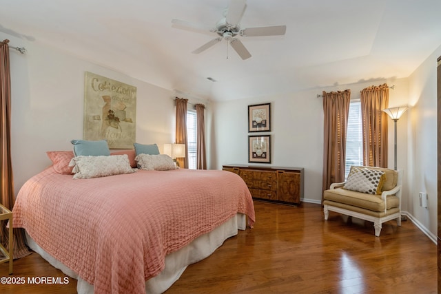 bedroom with ceiling fan, multiple windows, and dark hardwood / wood-style floors