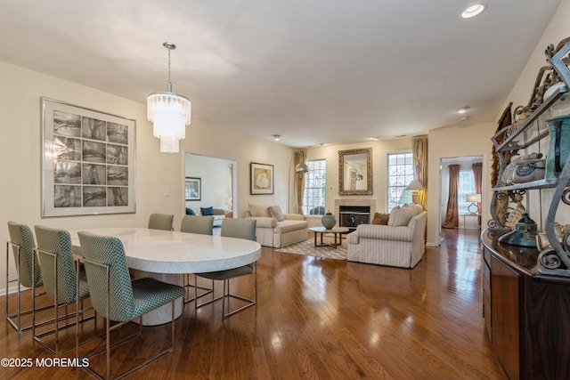 dining space with dark hardwood / wood-style floors and a notable chandelier