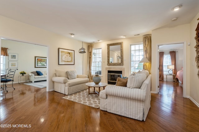 living room featuring a healthy amount of sunlight, wood-type flooring, and a tile fireplace