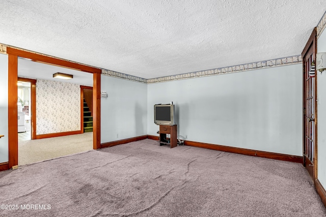 carpeted empty room with a textured ceiling