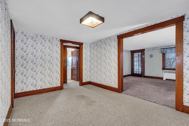 empty room with light colored carpet and radiator heating unit