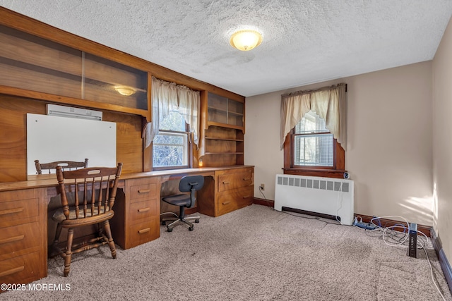 office with radiator, a textured ceiling, and light carpet