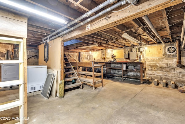 basement featuring fridge and a workshop area