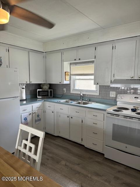 kitchen with dark hardwood / wood-style floors, tasteful backsplash, white appliances, white cabinets, and sink