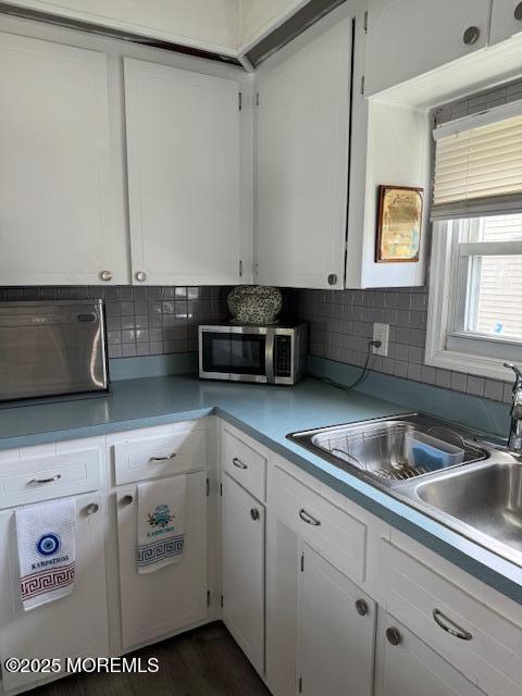 kitchen featuring decorative backsplash, sink, white cabinets, and dark hardwood / wood-style floors