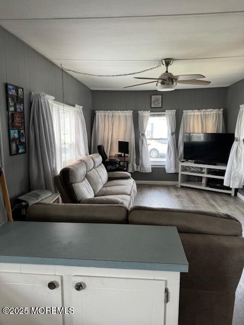 living room featuring ceiling fan, plenty of natural light, and hardwood / wood-style flooring