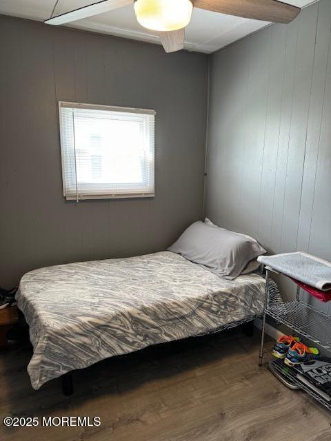 bedroom featuring ceiling fan, beam ceiling, and hardwood / wood-style floors