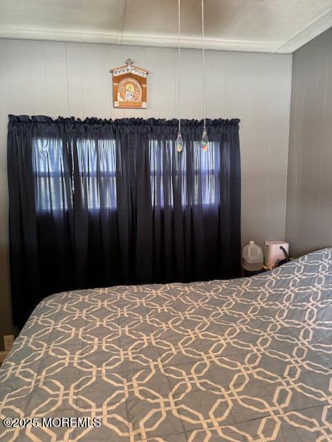 bedroom featuring wooden walls