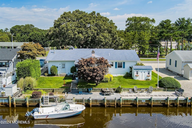 back of house featuring a yard and a water view