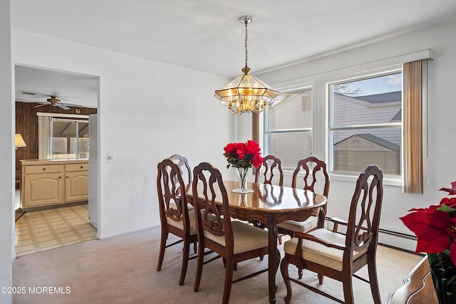 dining room featuring baseboard heating, wood walls, and ceiling fan with notable chandelier