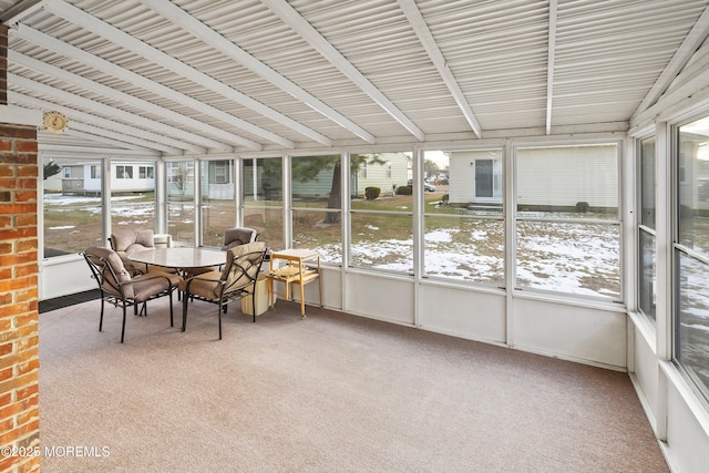 sunroom featuring vaulted ceiling and a healthy amount of sunlight