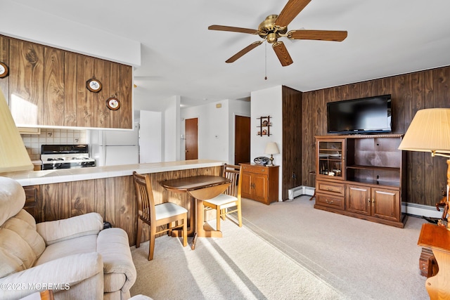 carpeted living room with wooden walls, ceiling fan, and a baseboard radiator