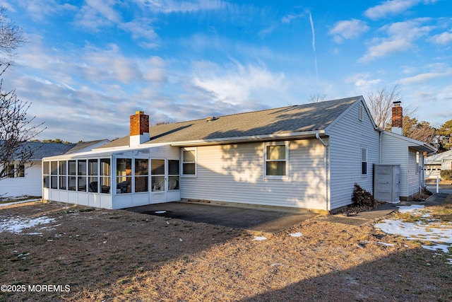 rear view of house featuring a patio area and a sunroom