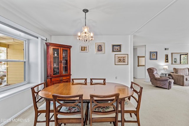 carpeted dining space featuring an inviting chandelier