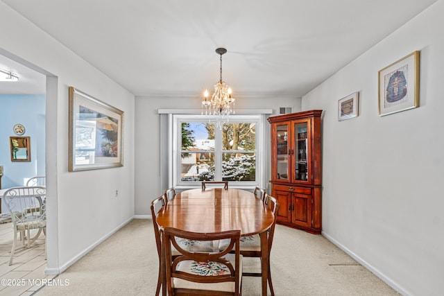 dining space with light colored carpet and a notable chandelier