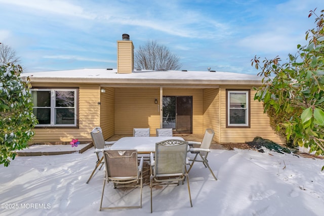 snow covered house featuring a patio