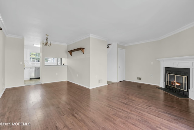 unfurnished living room with a notable chandelier, hardwood / wood-style floors, and crown molding