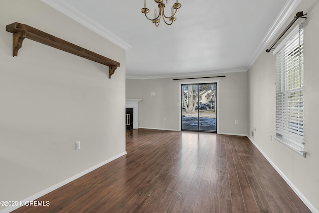 unfurnished living room with an inviting chandelier, crown molding, and dark hardwood / wood-style floors