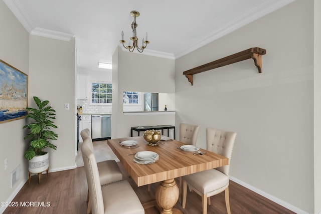 dining space with an inviting chandelier, ornamental molding, and dark hardwood / wood-style flooring