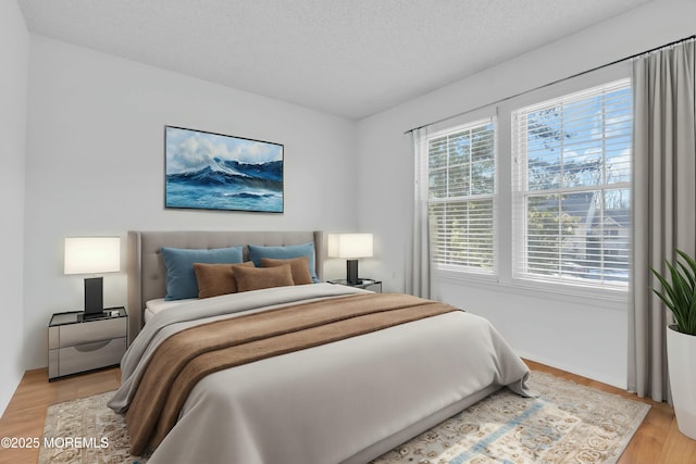 bedroom with a textured ceiling and light hardwood / wood-style floors