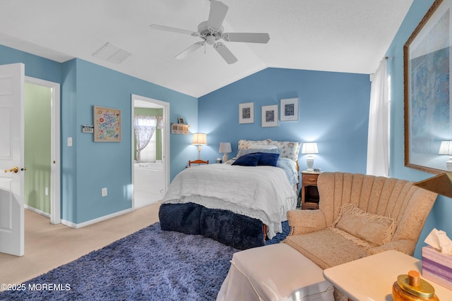 bedroom featuring ceiling fan, light colored carpet, ensuite bathroom, and lofted ceiling