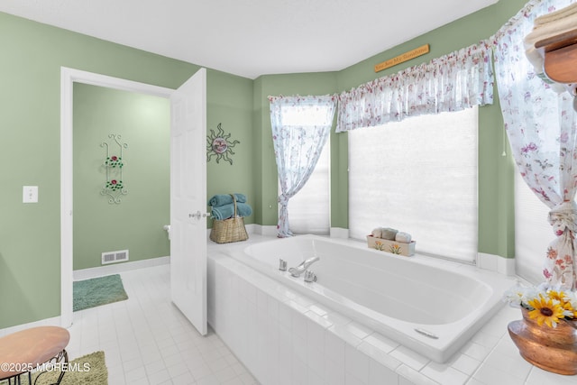 bathroom featuring tile patterned flooring and a relaxing tiled tub